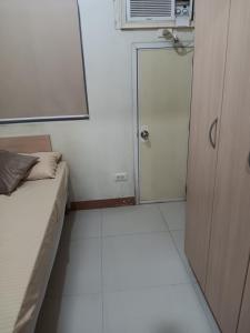 a small room with a bed and a window and a door at October Homes, Field Residences, Sucat, Parañaque, Airport Express in Manila