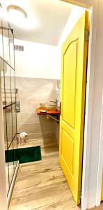 bagno con porta gialla e doccia di Marvelsun a Le Lamentin