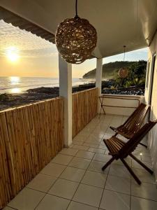 a porch with a chair and a view of the ocean at Surf House Mizata in Santa María Mizata