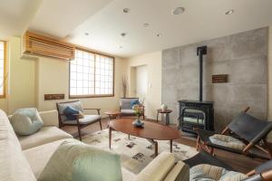 a living room with a couch and a fireplace at Residence Yasushi in Nozawa Onsen
