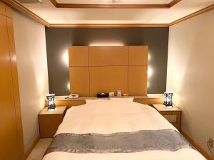a bedroom with a large bed and two night stands at Hotel Pareo (Adult Only) in Kobe