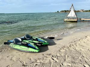 un par de kayaks sentados en una playa cerca del agua en Beachfront Glamping, en San Pedro 2 fotos más