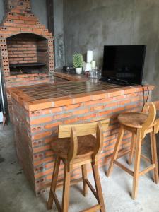 a large brick bar with two chairs and a television at Aluguel festival de Parintins in Parintins