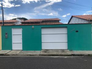 a green and white building with two garage doors at Aluguel festival de Parintins in Parintins