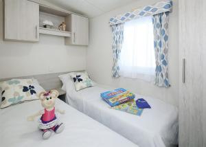 um quarto com duas camas e um rato de brinquedo numa scooter em Springhouse Country Park em Slaley