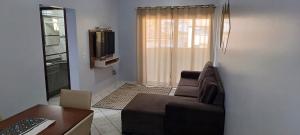ein Wohnzimmer mit einem Sofa und einem TV in der Unterkunft Apartamento 202 mobiliado 2 quartos em Jaraguá do Sul in Jaraguá do Sul