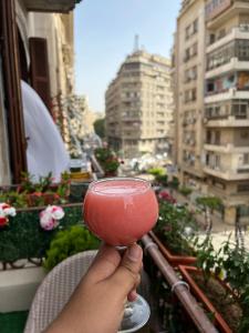 una persona che tiene in mano una bevanda rosa di Heaven Hostel a Il Cairo