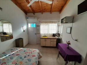 a bedroom with a bed and a table and a sink at Departamentos Tere in Las Grutas