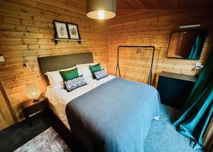 a bedroom with a bed in a wooden wall at Pant Wilkin Lodges And Equestrian Centre in Cowbridge