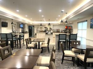 a restaurant with tables and chairs and a kitchen at Staybridge Suites Columbia-Highway 63 & I-70, an IHG Hotel in Columbia