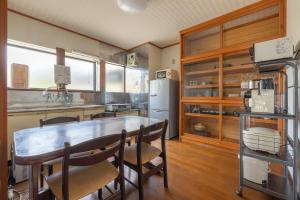 cocina con mesa, sillas y nevera en Kalik House, en Nozawa Onsen