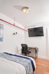 1 dormitorio con cama, escritorio y silla en Comfy Guest House in Hell's Kitchen, en Nueva York