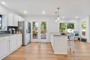 una cucina con armadietti bianchi e pavimenti in legno di Middle Sound Hideaway~Beaches, Shopping, Families a Wilmington