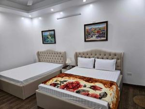 um quarto com duas camas e duas fotografias na parede em Hoàng Gia Hotel Royal 
