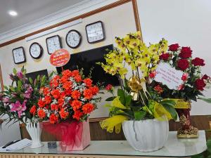 Hoàng Gia Hotel Royal : مزهرين مليئين بالورود على طاولة مع ساعات