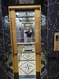 eine Person, die ein Bild von einem Spiegel in einem Aufzug macht in der Unterkunft Hoàng Gia Hotel Royal 