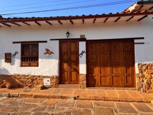 Una casa con dos puertas de madera. en Casa La Bonita - Barichara en Barichara