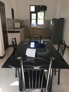 a black table and chairs in a room at Bosadi Homestay in Katunayake
