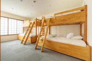 a bunk bed room with two bunk beds at Kawazen in Nozawa Onsen