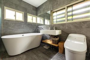 野澤溫泉的住宿－Kawazen，带浴缸、盥洗盆和卫生间的浴室