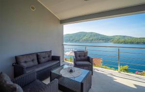 een balkon met een bank en stoelen en uitzicht op het water bij Stunning Home In Vela Luka With Kitchen in Vela Luka
