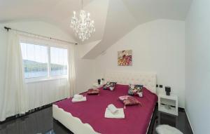 een slaapkamer met een groot bed met paarse lakens en kussens bij Stunning Home In Vela Luka With Kitchen in Vela Luka