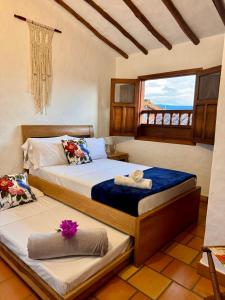 two beds in a room with a window at Casa La Bonita - Barichara in Barichara