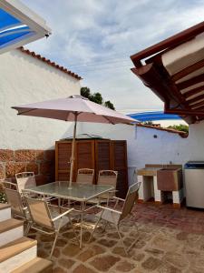 Casa La Bonita - Barichara في باريكارا: طاولة وكراسي مع مظلة على الفناء