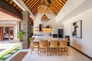 an open kitchen and dining room with a table and chairs at VILLA JIWA SANUR in Sanur