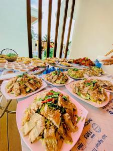 a table with plates of food on it at Khách Sạn The Rice Cái Bè in Cai Be
