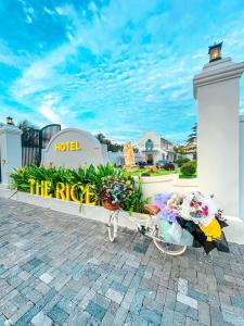 uma bicicleta estacionada em frente a um hotel com flores em Khách Sạn The Rice Cái Bè em Cái Bè