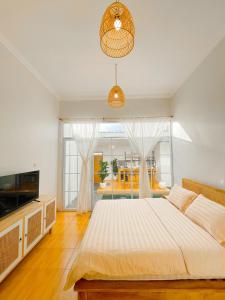 1 dormitorio con cama grande y ventana grande en OsCo Paviliun en Timuran