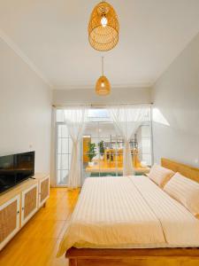a bedroom with a large bed and a large window at OsCo Paviliun in Yogyakarta