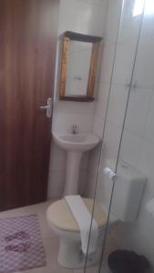 uma casa de banho com um WC, um lavatório e um espelho. em Aurora suites chapada Diamantina em Lençóis