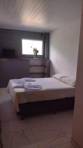 um quarto com uma cama grande e uma janela em Aurora suites chapada Diamantina em Lençóis