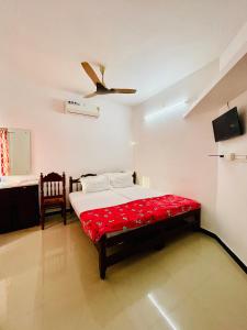 - une chambre avec un lit et un ventilateur de plafond dans l'établissement Eden Homestay Alleppey, à Alappuzha