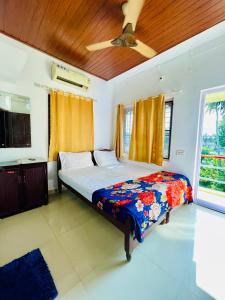 um quarto com uma cama e uma ventoinha de tecto em Eden Homestay Alleppey em Alappuzha