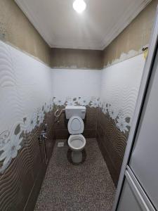 een kleine badkamer met een toilet in een stal bij HOMESTAY TOKMA PASIR MAS in Pasir Mas