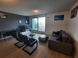 ein Wohnzimmer mit Sofa und Klavier in der Unterkunft Appartement Anglet, 2 pièces, 4 personnes - FR-1-239-1021 in Anglet