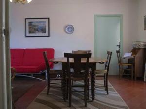 une chambre avec une table, des chaises et un canapé rouge dans l'établissement Villa Argelès-sur-Mer, 5 pièces, 6 personnes - FR-1-776-71, à Argelès-sur-Mer