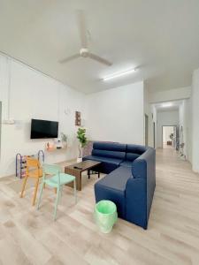 a living room with a blue couch and a table at Coliving room renting Homestay Yong Peng in Yong Peng