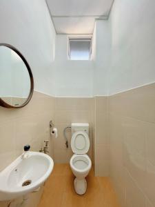 a bathroom with a sink and a toilet and a mirror at Coliving room renting Homestay Yong Peng in Yong Peng