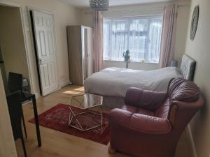 a bedroom with a bed and a couch and a chair at Lovely Studio in Town Centre in Reading