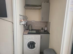 a small kitchen with a washing machine and a sink at Lovely Studio in Town Centre in Reading