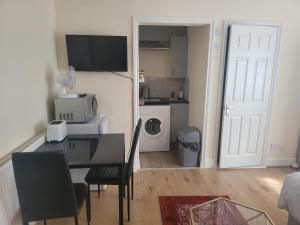 a room with a dining room table and a kitchen at Lovely Studio in Town Centre in Reading