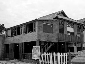 ein Holzhaus mit einem Schild davor in der Unterkunft nhà gỗ homestay nguyên văn in Hưng Lương