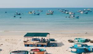 un gruppo di barche sedute sulla spiaggia di nhà gỗ homestay nguyên văn a Hưng Lương