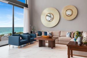 a living room with a couch and chairs and a table at Villa E11even con C hef Privado Ocean Front in Isla Mujeres