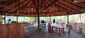 a restaurant with wooden tables and chairs and people in the background at BOLAVEN GARDEN Bungalow and tent - Tad Lo in Ban Kiangtat