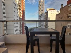 a black table and chairs on a balcony with a view at Parque España Rio in Rosario
